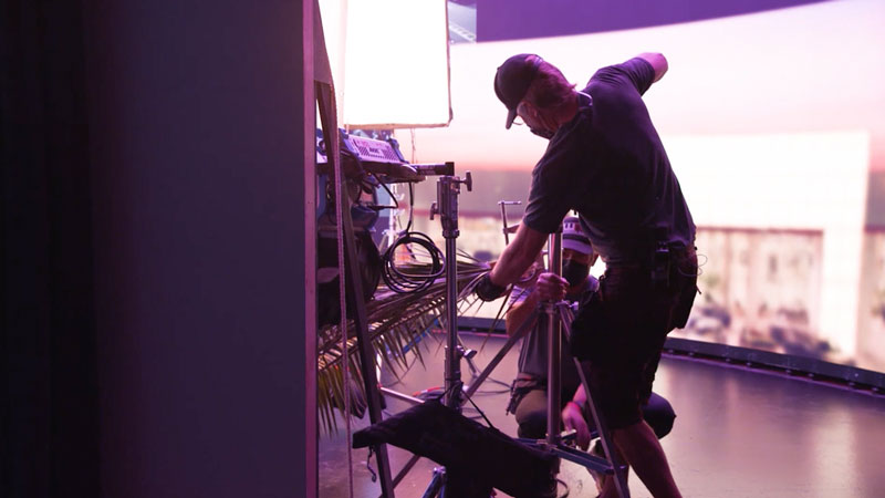 A filmmaking grip using palm leaves to hide the LED wall on set