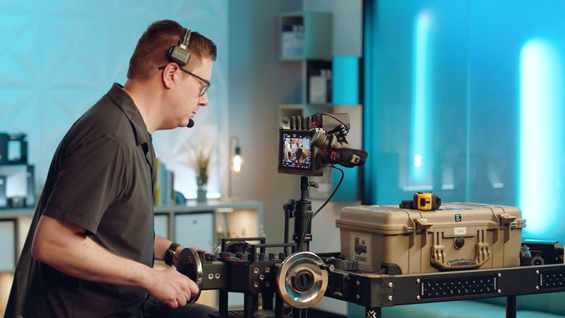 Filmmaker operating wheels with DJI Ronin FLEX with jib arm