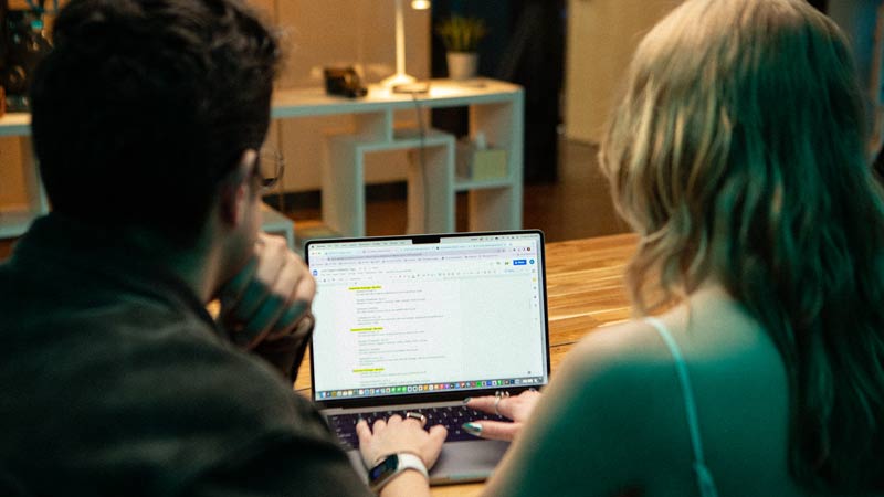 Social media experts looking at computer screen 
